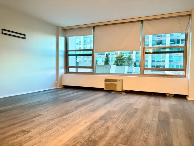 a view of a room with wooden floor and a window