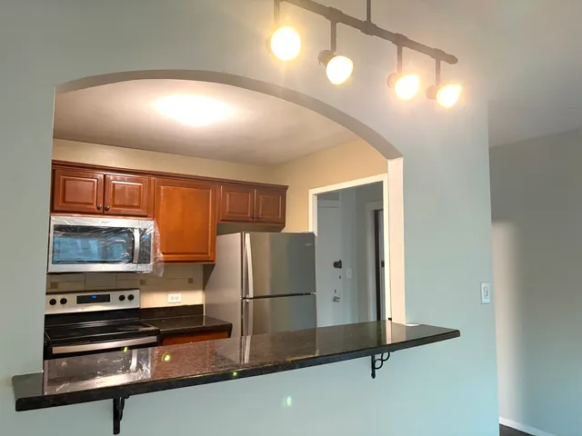 a kitchen with stainless steel appliances a refrigerator and microwave