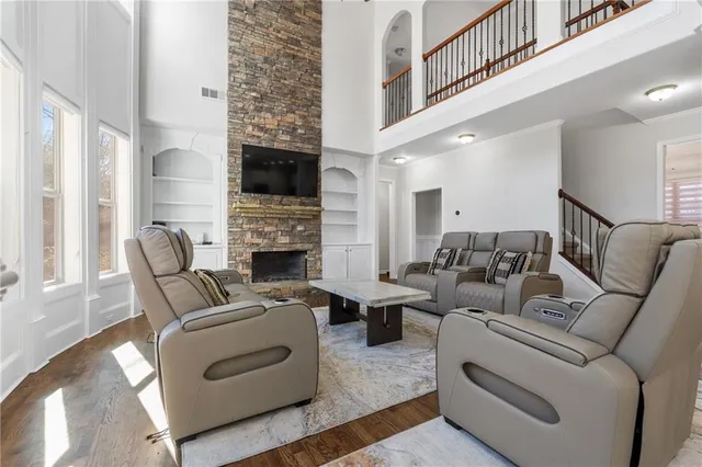 a living room with furniture a fireplace and a flat screen tv
