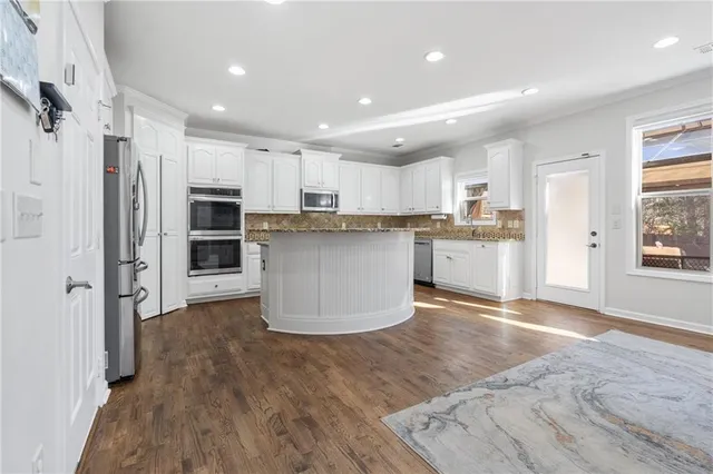 a kitchen with stainless steel appliances a refrigerator and a stove top oven