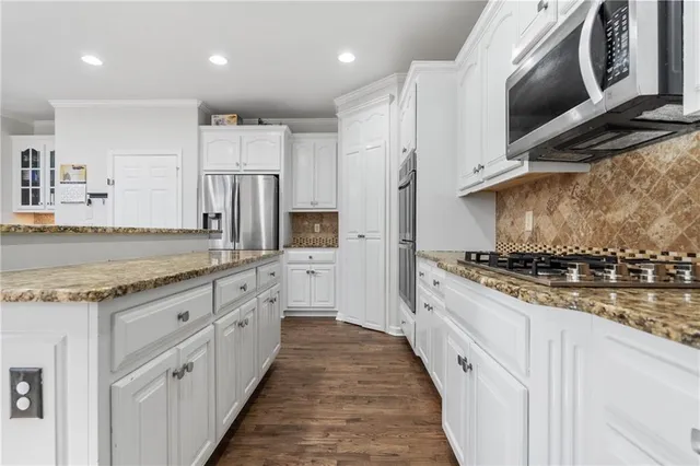 a large kitchen with stainless steel appliances granite countertop a stove and a sink