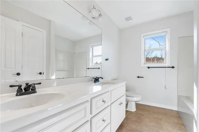 a spacious bathroom with a double vanity sink a mirror and a bathtub