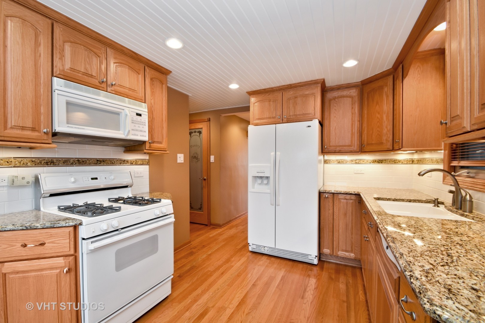 5155 South Mobile Avenue Chicago, IL 60638 - Photo 3 of 10 a kitchen with a refrigerator a stove top oven and wooden floors