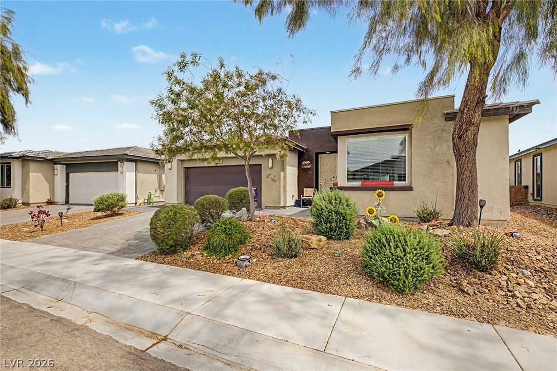 4914 East Beacon Ridge Drive Pahrump, NV 89061 - Photo 7 of 34 A well-maintained facade features mature landscaping and convenient garage access.