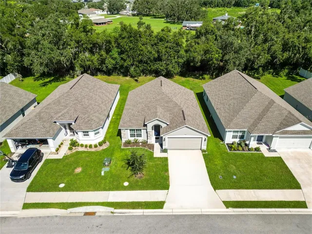 an aerial view of a house with a garden and trees