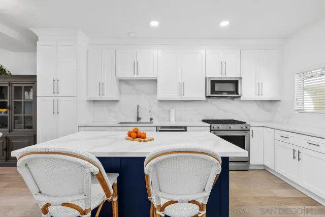 a kitchen with stainless steel appliances granite countertop a sink stove and cabinets