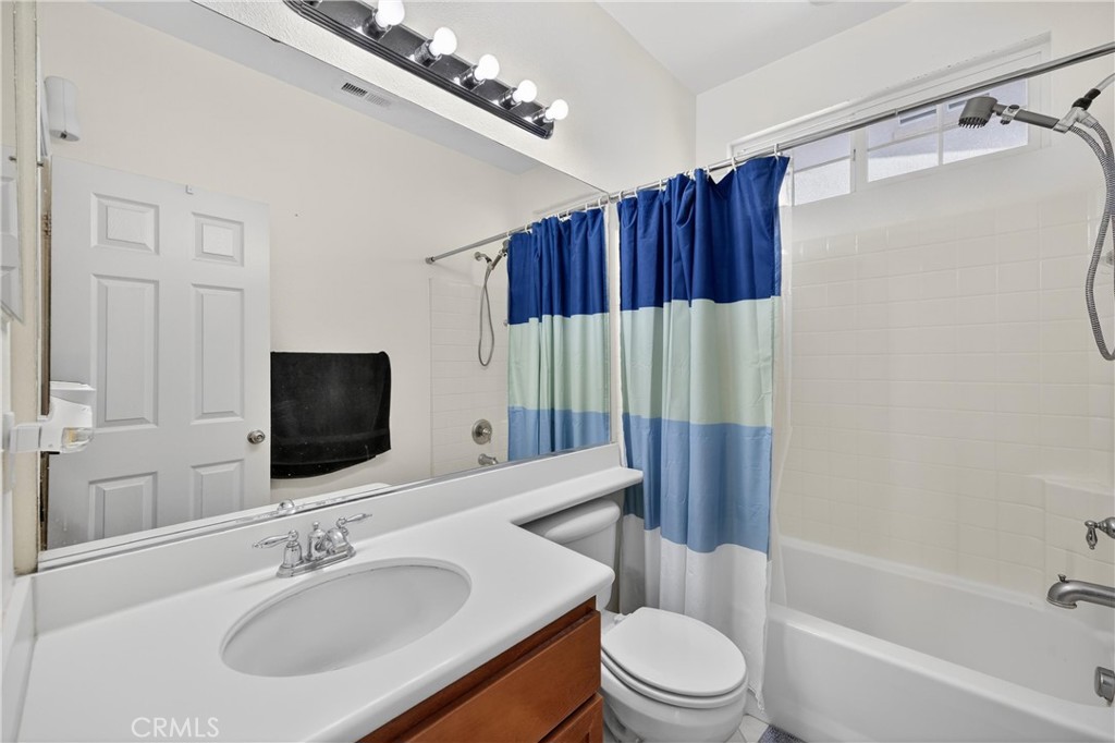 34581 Spindle Tree Street Winchester, CA 92596 - Photo 12 of 50 a bathroom with a sink a toilet a mirror a vanity and bathtub