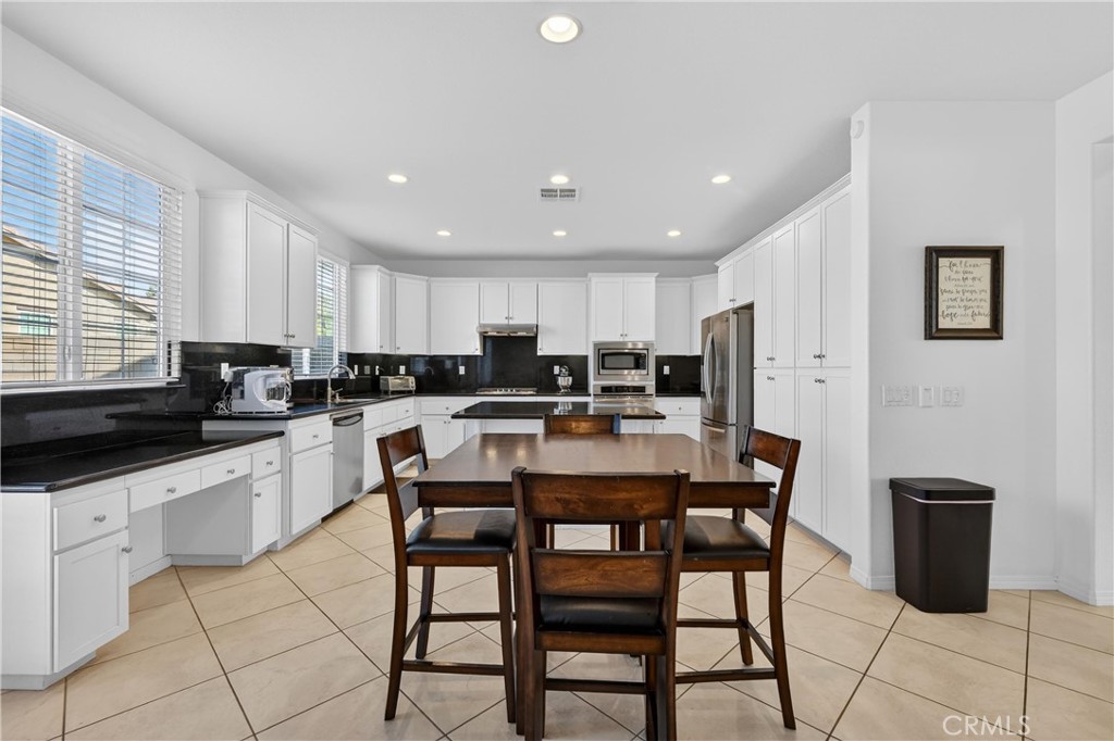 34581 Spindle Tree Street Winchester, CA 92596 - Photo 20 of 50 a kitchen with stainless steel appliances granite countertop a stove a sink a refrigerator a microwave and cabinets