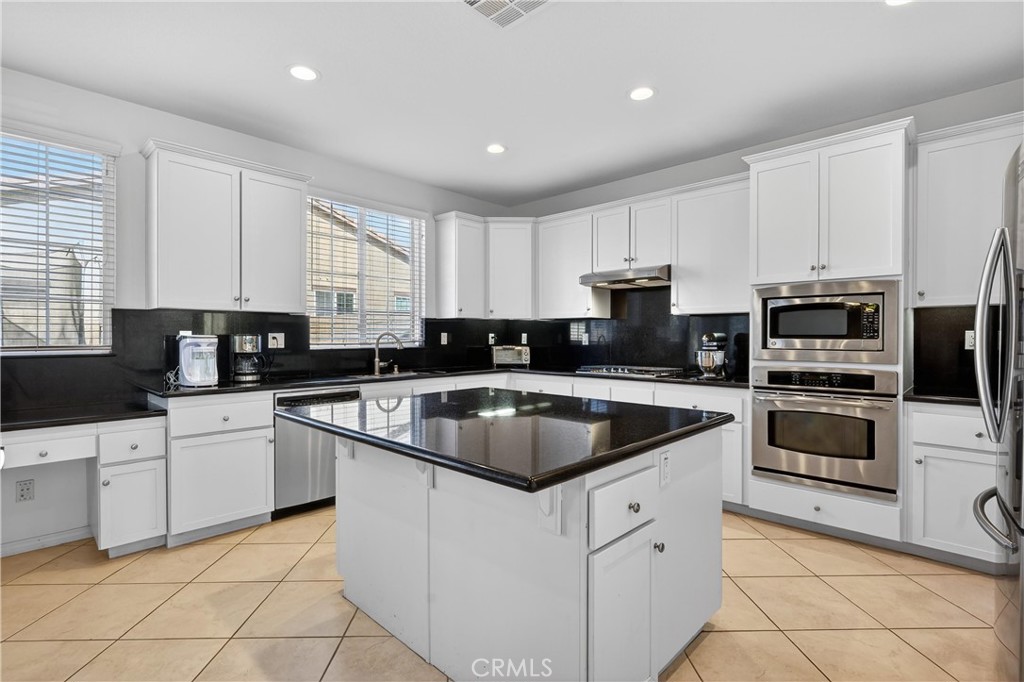 34581 Spindle Tree Street Winchester, CA 92596 - Photo 23 of 50 a kitchen with granite countertop white cabinets sink and stainless steel appliances