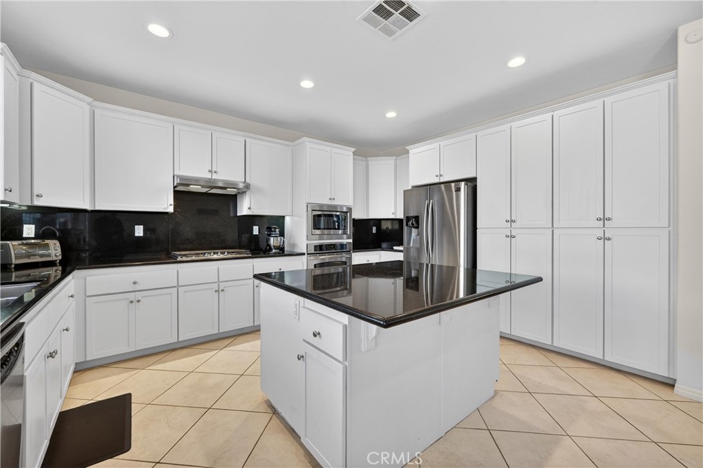 34581 Spindle Tree Street Winchester, CA 92596 - Photo 24 of 50 a kitchen with granite countertop white cabinets and stainless steel appliances
