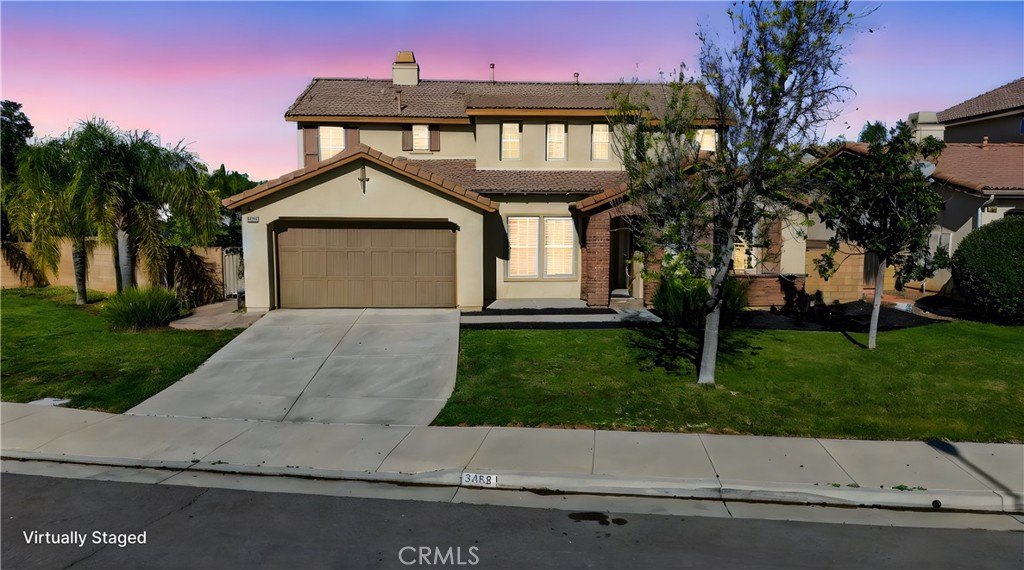 34581 Spindle Tree Street Winchester, CA 92596 - Photo 3 of 50 a front view of a house with a yard and a garage