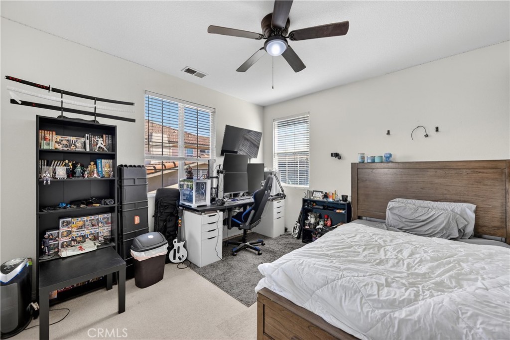 34581 Spindle Tree Street Winchester, CA 92596 - Photo 31 of 50 a bedroom with a bed large window and book shelf