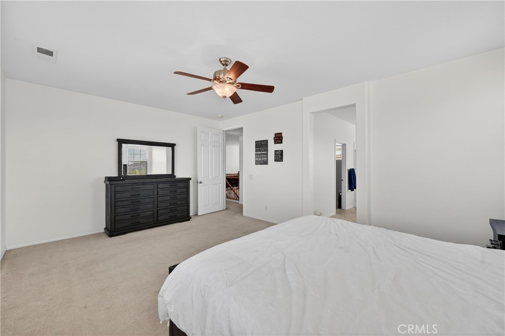 34581 Spindle Tree Street Winchester, CA 92596 - Photo 39 of 50 a bedroom with a large bed and a chandelier