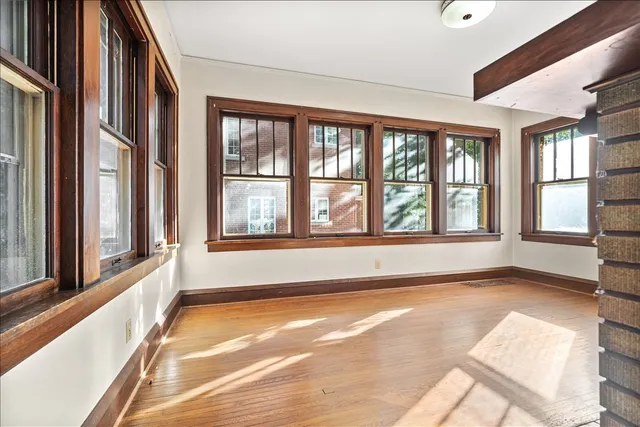 a view of an empty room with a window and a kitchen