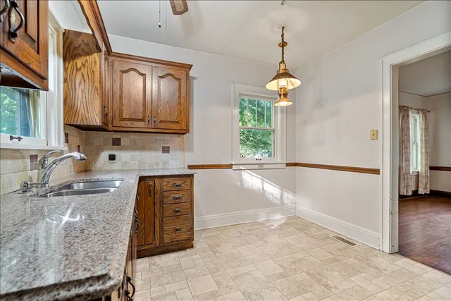 a kitchen with granite countertop a sink cabinets and window