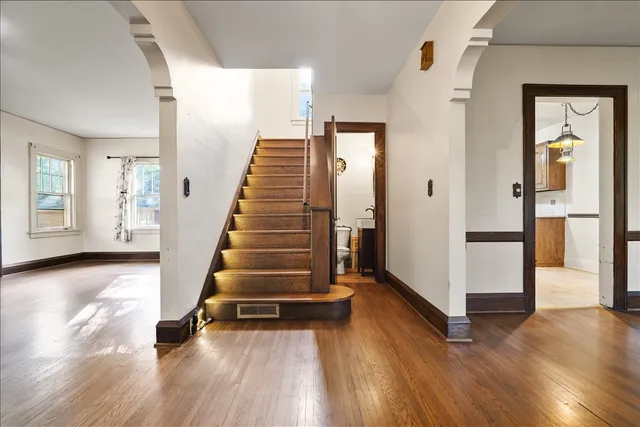 a view of a hallway with wooden floor and staircase