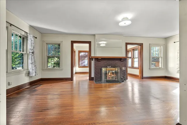 an empty room with floor to ceiling windows and fireplace