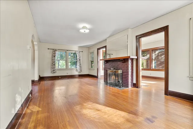 a view of a livingroom with wooden floor and a fireplace