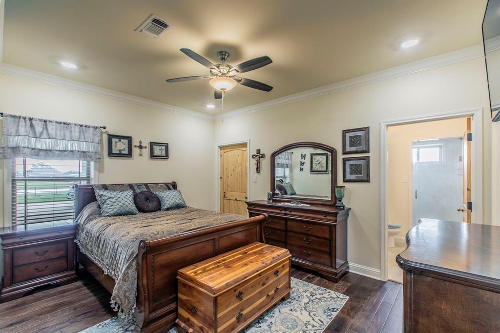 790 Bones Chapel Road Whitesboro, TX 76273 - Photo 16 of 36 a bedroom with a bed and a dresser with wooden floor