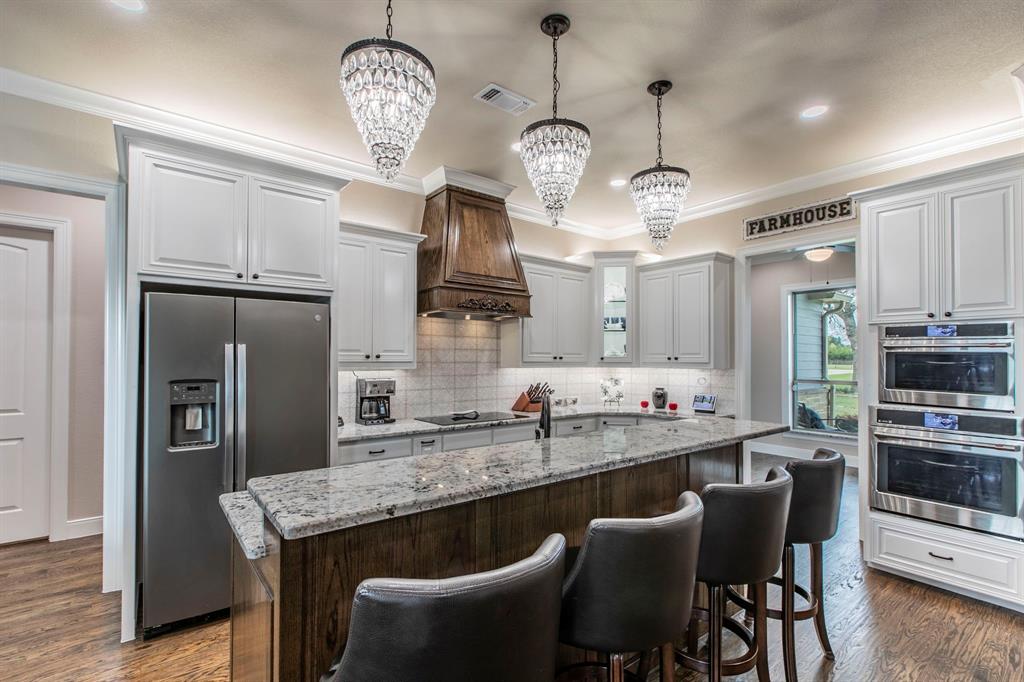 790 Bones Chapel Road Whitesboro, TX 76273 - Photo 5 of 36 a kitchen with stainless steel appliances granite countertop a sink a stove a refrigerator and a chandelier