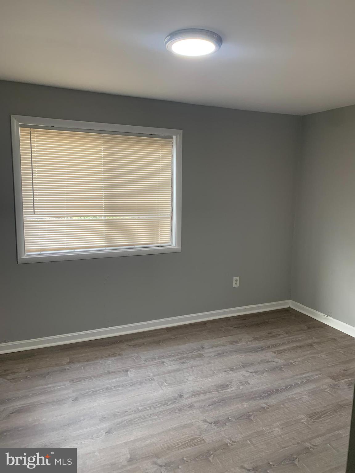 5404 67th Avenue Riverdale, MD 20737 - Photo 8 of 11 an empty room with wooden floor and windows