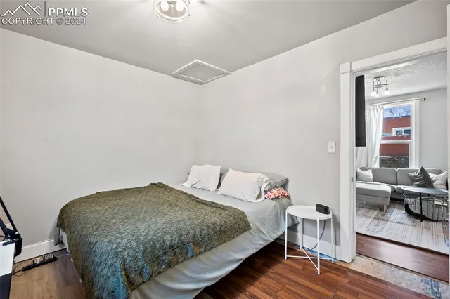 a bedroom with a bed and wooden floor
