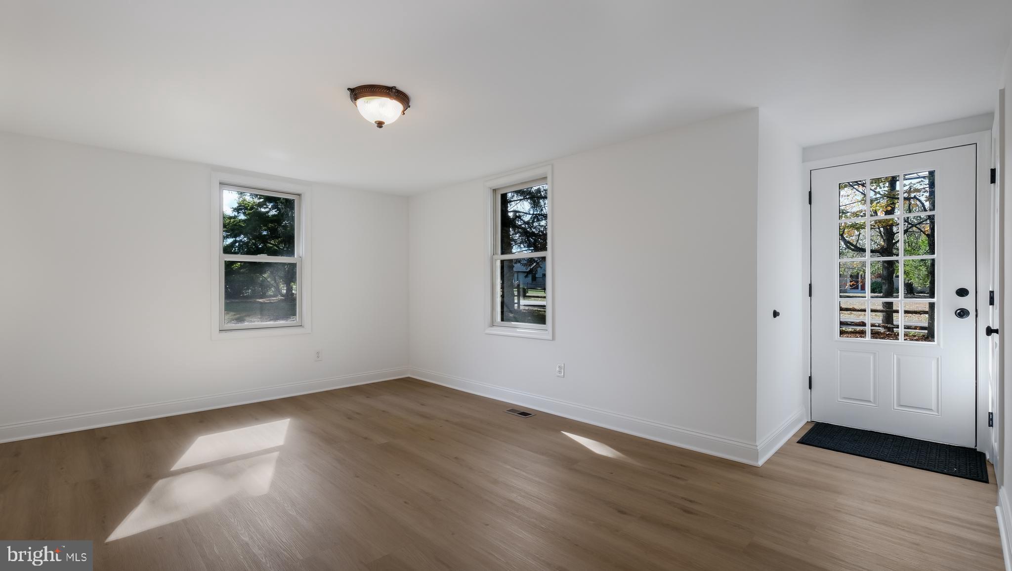 2443 Sugar Bottom Road Furlong, PA 18925 - Photo 5 of 39 an empty room with wooden floor and windows