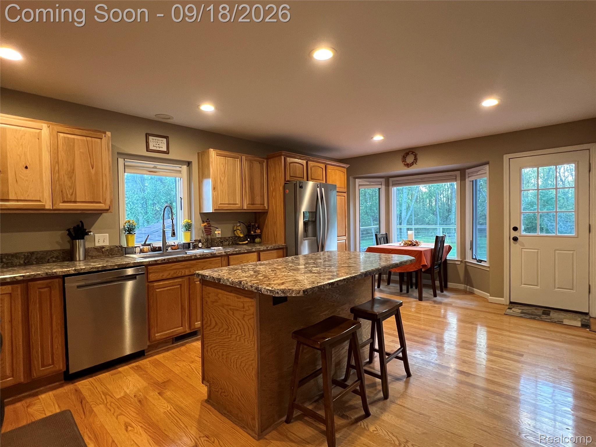 7070 Elms Road Swartz Creek, MI 48473 - Photo 6 of 27 Kitchen featuring wood cabinetry, stainless steel appliances, a center island with countertop, hardwood flooring, and recessed lighting