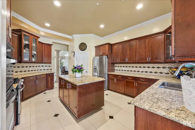 a kitchen with stainless steel appliances granite countertop a stove top oven a sink dishwasher and wooden cabinets with wooden floor