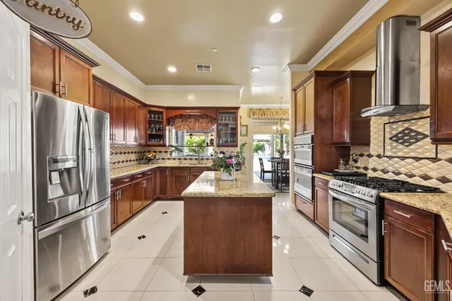a kitchen with stainless steel appliances granite countertop a refrigerator stove and sink