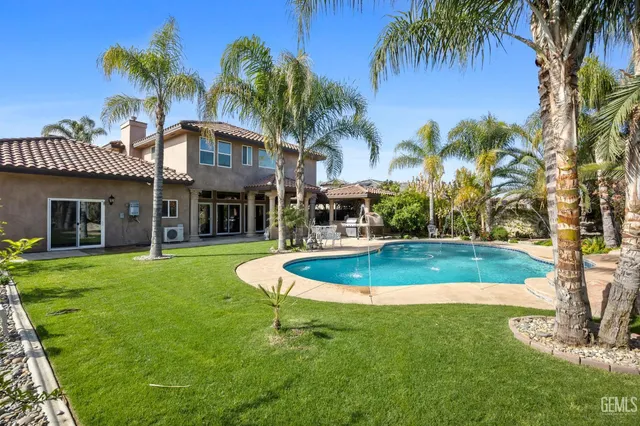 a view of a house with a swimming pool and a yard