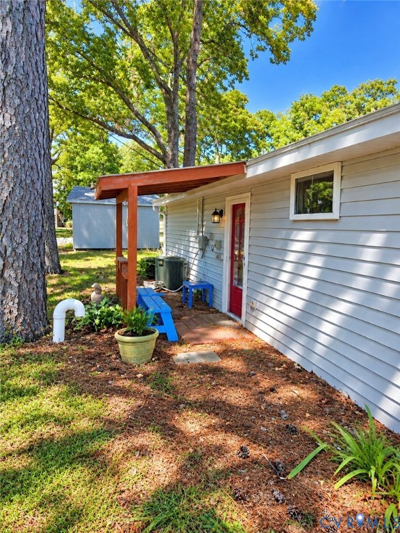 Exterior featuring light grey siding, a red entry