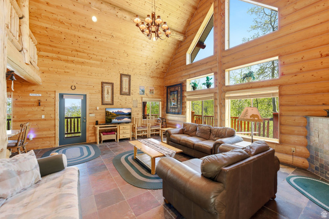 2096 South Aspen Ridge Coalville, UT 84017 - Photo 10 of 44 Vaulted ceiling great room featuring exposed log walls, large picture windows, and natural stone flooring