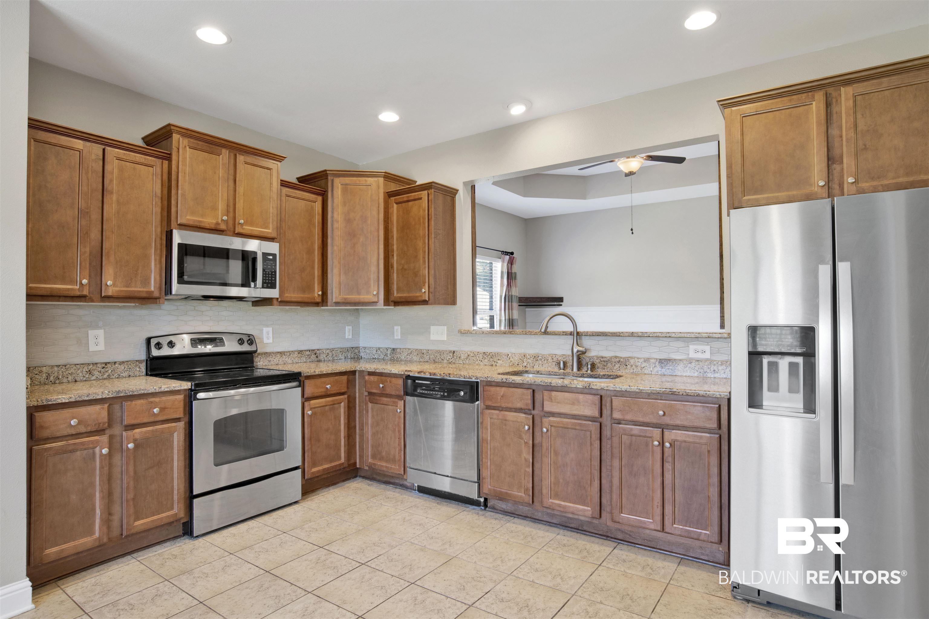24159 Tullamore Drive Daphne, AL 36526 - Photo 13 of 31 Kitchen with stainless steel appliances, sink, light tile patterned flooring, light stone counters, and ceiling fan