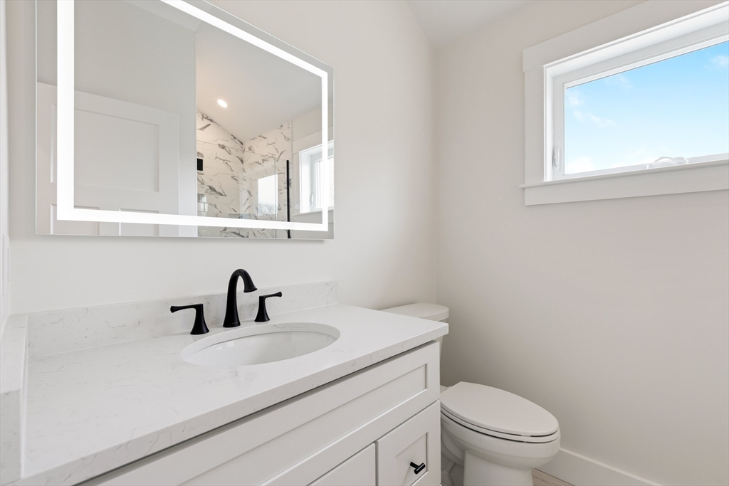 2 Old County Road, Unit 14 Salisbury, MA 01952 - Photo 19 of 33 a bathroom with a toilet a sink and mirror