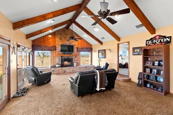 a living room with furniture a fireplace and a chandelier