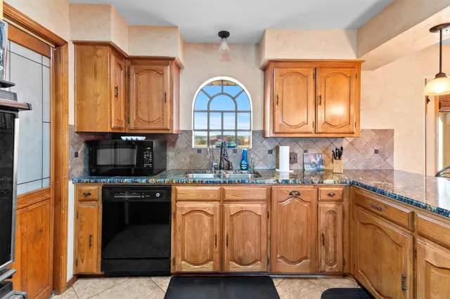 a kitchen with stainless steel appliances granite countertop a stove a sink and a microwave