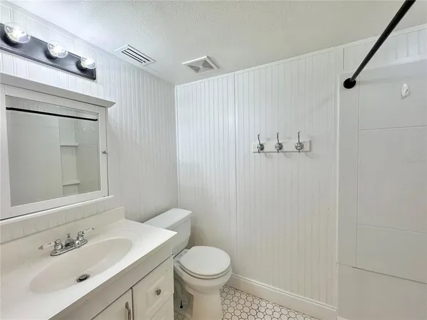 an empty room with a fan & a ceiling fan
