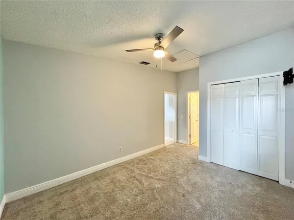 an empty room with a chandelier fan