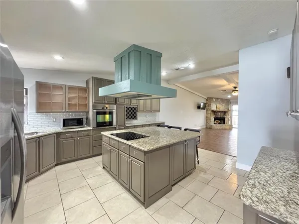 a kitchen with stainless steel appliances granite countertop a stove a sink and a refrigerator