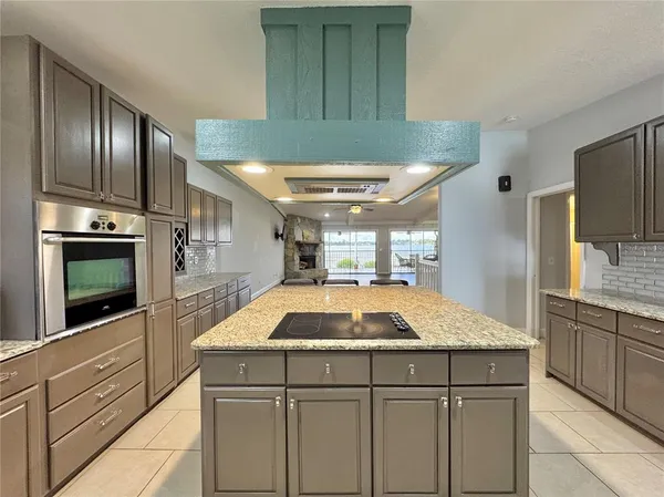 a kitchen with kitchen island granite countertop cabinets and stainless steel appliances