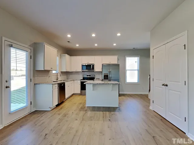 a kitchen with a refrigerator and a stove top oven