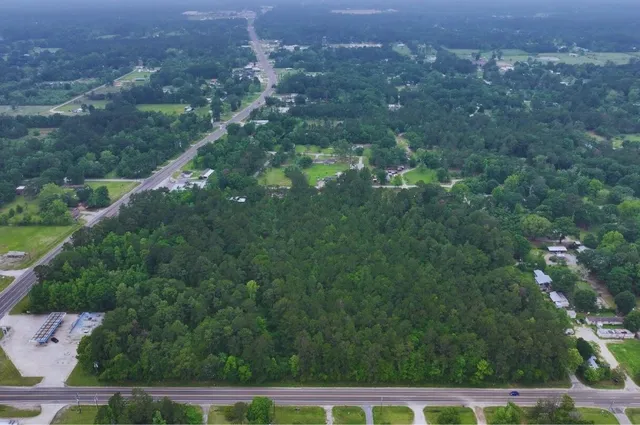 an aerial view of residential houses with outdoor space and trees
