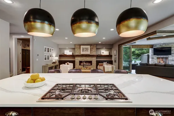 a kitchen with stainless steel appliances granite countertop a stove a sink and a dining table with wooden floor