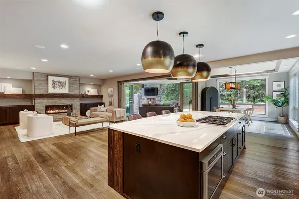 a kitchen with stainless steel appliances granite countertop a sink a stove and a wooden floors