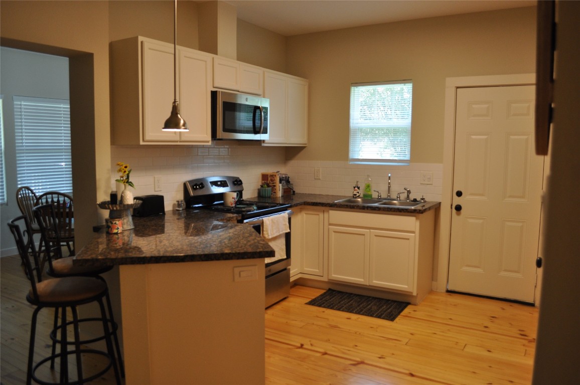 913 Independence Street Brenham, TX 77833 - Photo 16 of 24 a kitchen with stainless steel appliances granite countertop a sink a stove a microwave a counter top space and cabinets