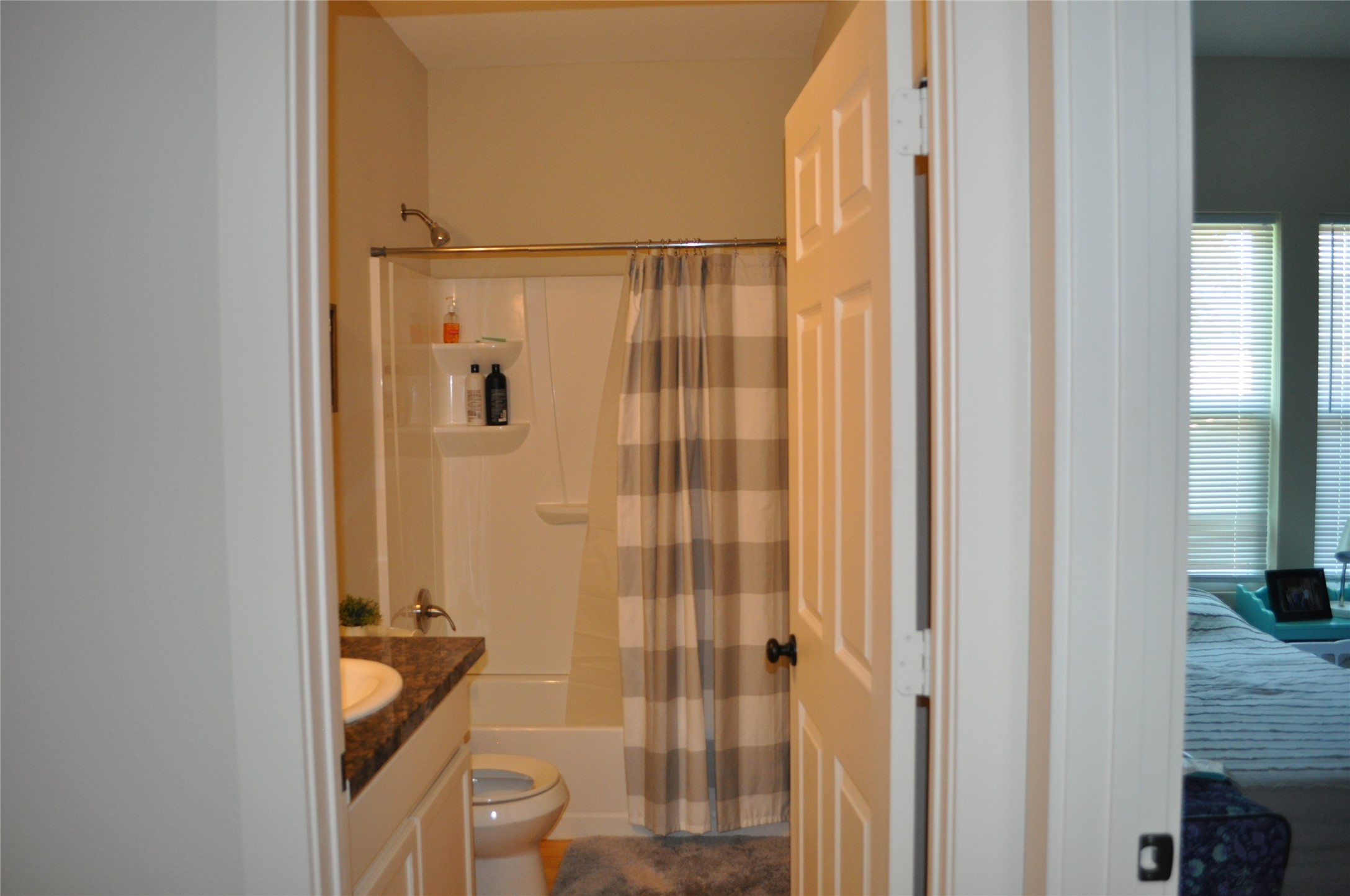 913 Independence Street Brenham, TX 77833 - Photo 20 of 24 a bathroom with a granite countertop sink and a mirror