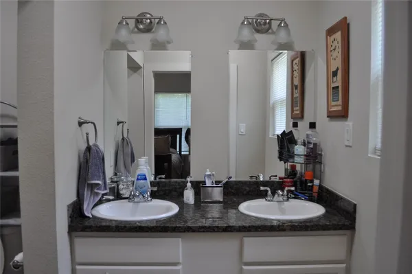 a bathroom with double vanity sinks and a mirror