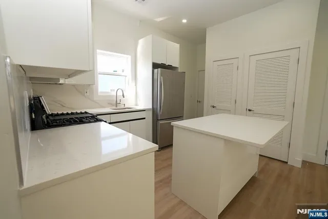 a kitchen with a refrigerator and a stove top oven