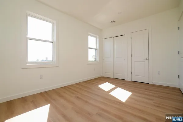 a view of empty room with window and wooden floor